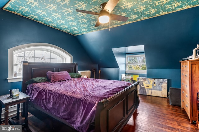 bedroom with radiator, lofted ceiling, and hardwood / wood-style flooring