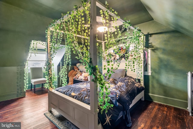 bedroom with baseboards, wood-type flooring, and lofted ceiling