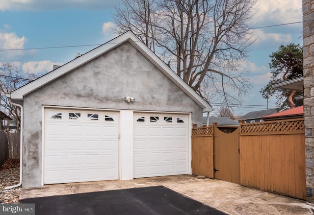 detached garage with a gate and fence