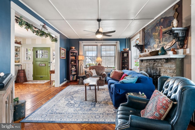 living room with baseboards, parquet floors, and ceiling fan