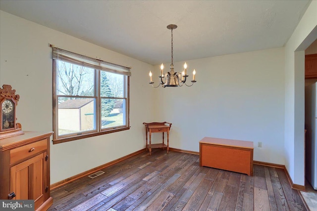 dining space with dark wood finished floors, baseboards, visible vents, and a chandelier