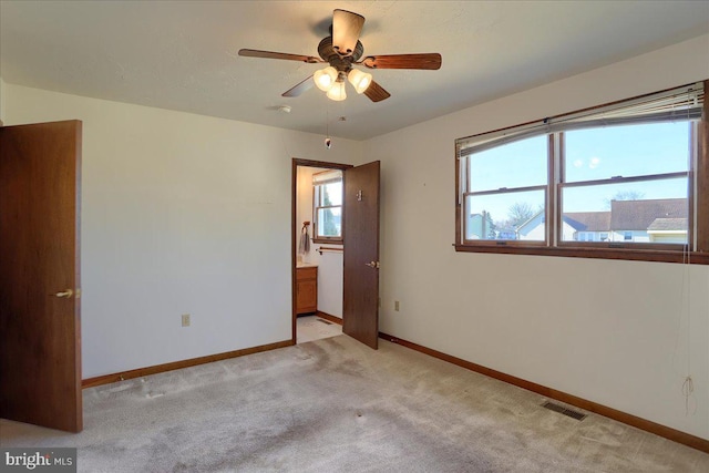 empty room with visible vents, baseboards, light colored carpet, and a ceiling fan