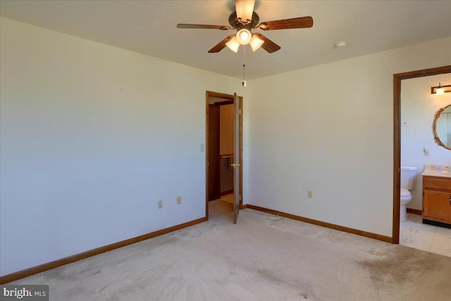 unfurnished bedroom with light carpet, ceiling fan, ensuite bathroom, and baseboards