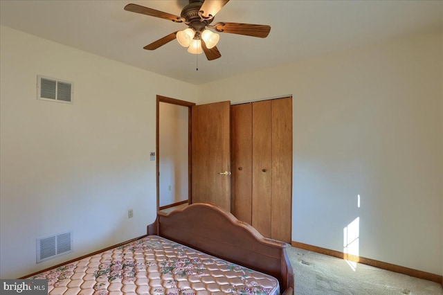 carpeted bedroom with a ceiling fan, baseboards, visible vents, and a closet