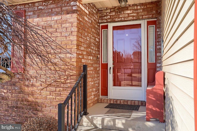 view of exterior entry featuring brick siding