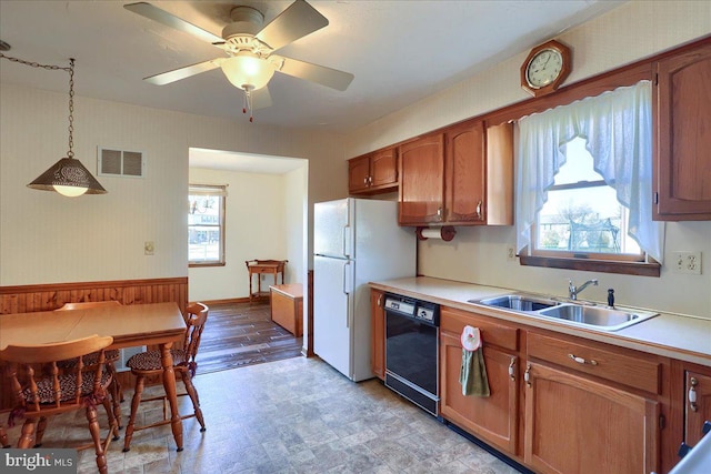 kitchen with visible vents, a sink, black dishwasher, freestanding refrigerator, and light countertops