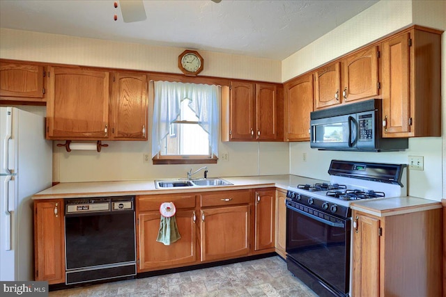 kitchen featuring black appliances, brown cabinetry, and a sink