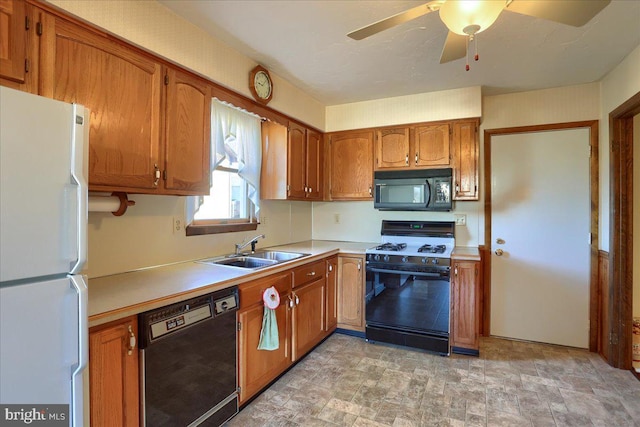 kitchen with light countertops, brown cabinetry, stone finish floor, black appliances, and a sink