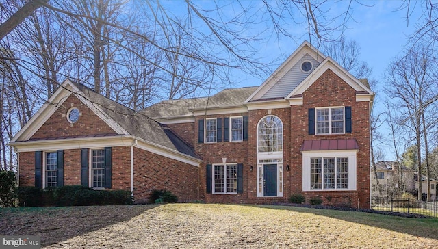 view of front of house featuring a front yard, fence, and brick siding