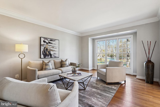 living room featuring wood finished floors, baseboards, and ornamental molding