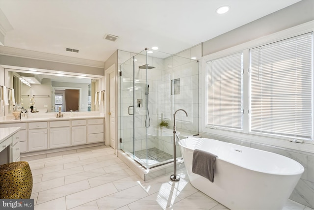 bathroom featuring visible vents, a soaking tub, a stall shower, and vanity