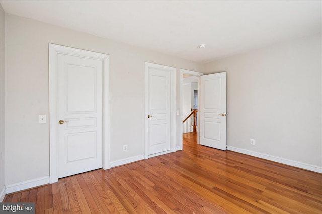 unfurnished bedroom with light wood-type flooring and baseboards