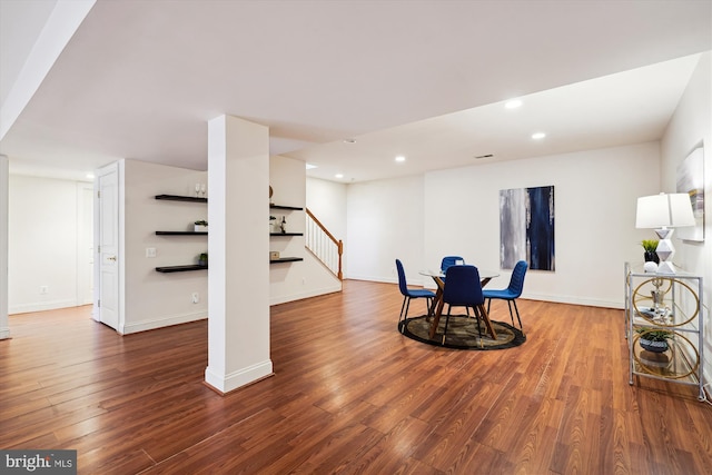 living area with recessed lighting, baseboards, wood finished floors, and stairs