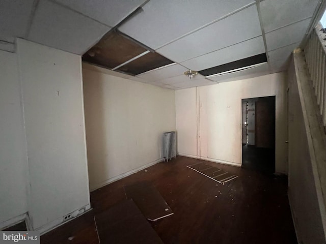 unfurnished room with a paneled ceiling and radiator heating unit