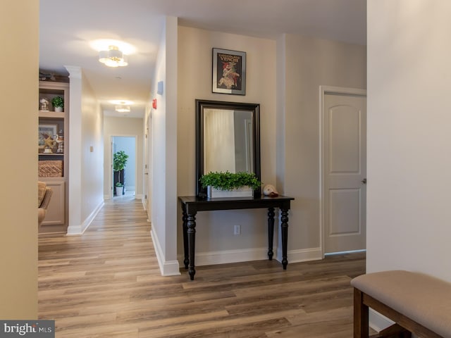 hall featuring light wood-type flooring and baseboards