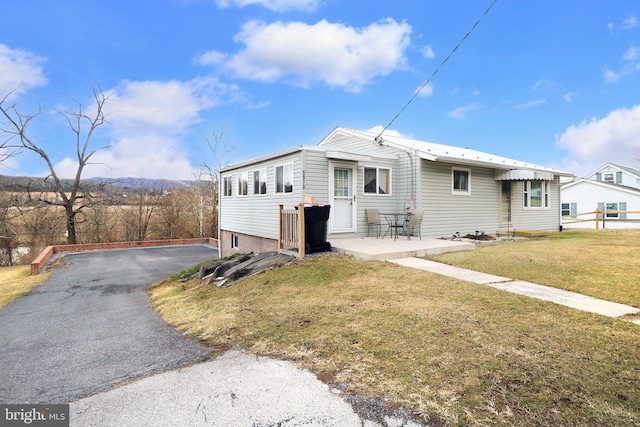 view of property exterior with a patio, a yard, and driveway