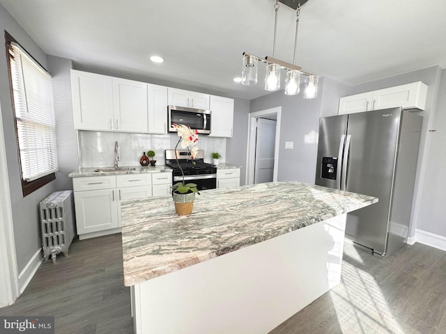 kitchen with white cabinets, radiator, and stainless steel appliances