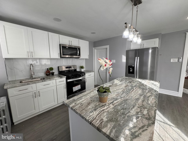 kitchen featuring light stone counters, dark wood-style floors, a sink, appliances with stainless steel finishes, and tasteful backsplash