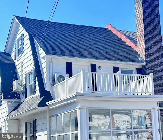 exterior space with ac unit and a shingled roof