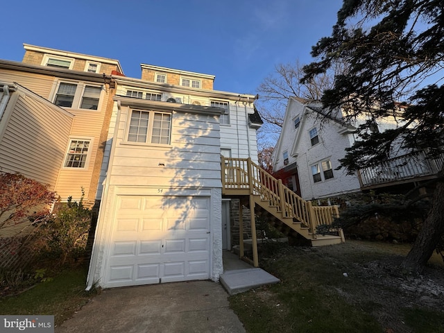 back of property featuring stairway and an attached garage