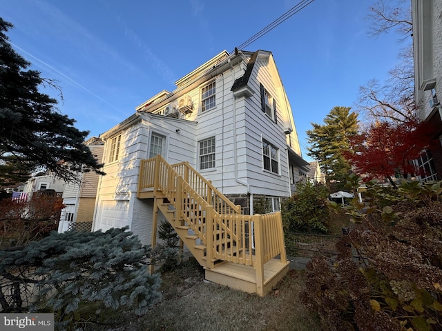 back of property with stairs and a garage