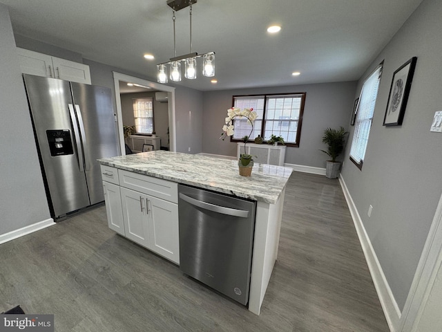 kitchen featuring stainless steel appliances, light stone countertops, dark wood-type flooring, and white cabinetry