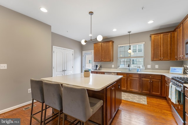 12831 Clarksburg Square Rd, Clarksburg, MD 20871 - kitchen featuring a sink, a breakfast bar, brown cabinets, stainless steel appliances, and a kitchen island