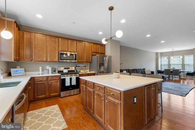 12831 Clarksburg Square Rd, Clarksburg, MD 20871 - kitchen with brown cabinetry, a center island, wood finished floors, and stainless steel appliances