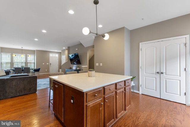 12831 Clarksburg Square Rd, Clarksburg, MD 20871 - kitchen with recessed lighting, a kitchen island, wood finished floors, open floor plan, and a breakfast bar area