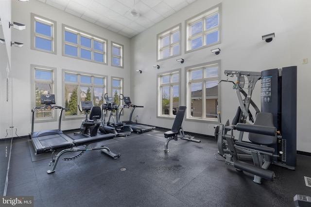 12831 Clarksburg Square Rd, Clarksburg, MD 20871 - gym featuring a drop ceiling, a high ceiling, baseboards, and a healthy amount of sunlight