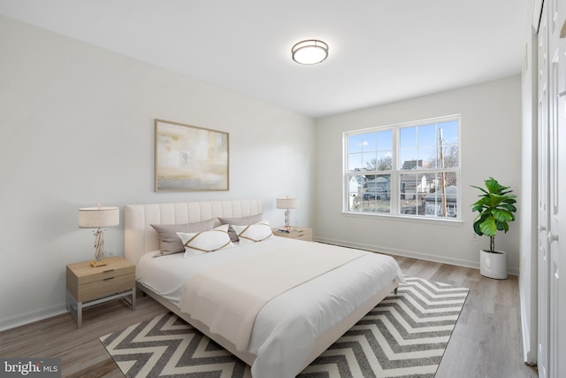 bedroom featuring baseboards and light wood-type flooring