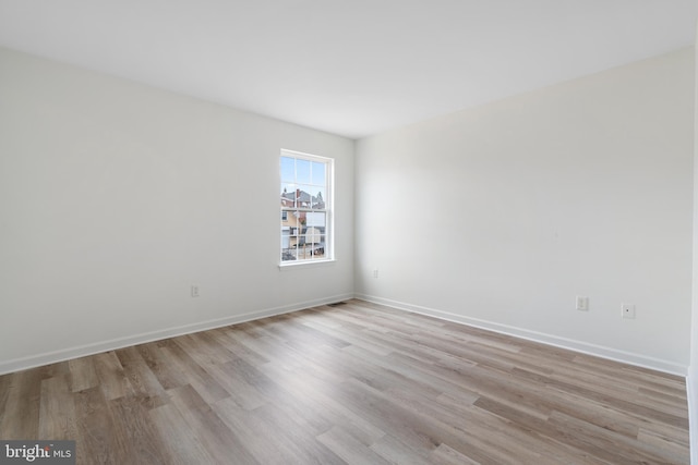 empty room featuring light wood-style flooring and baseboards