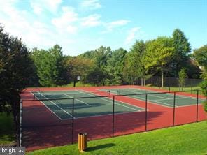 view of tennis court with a yard