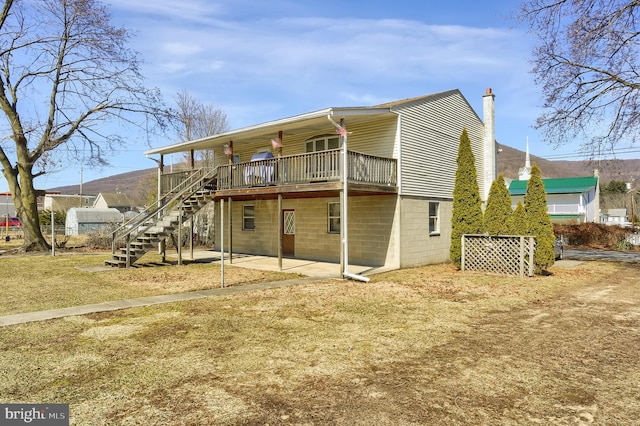 rear view of property with a deck, a patio, and stairway