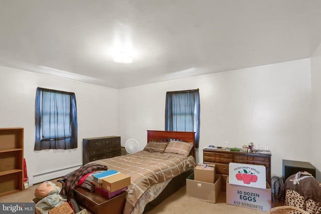 bedroom with a baseboard heating unit and carpet floors