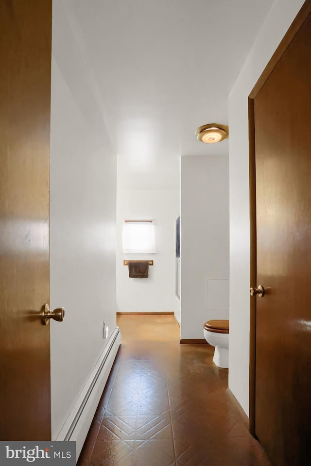 hallway featuring baseboards and a baseboard radiator