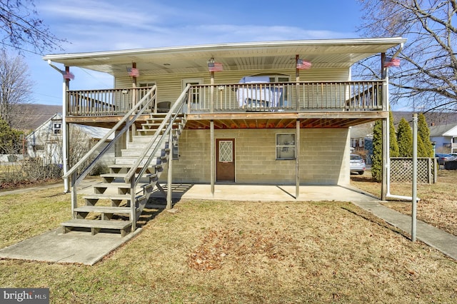 rear view of property with a yard, a deck, stairs, and a patio area