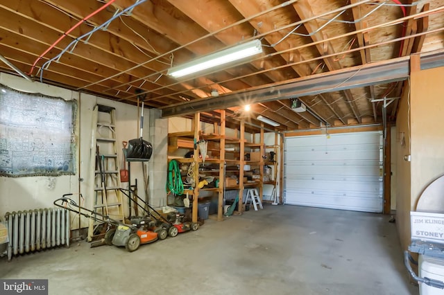 garage with a garage door opener and radiator heating unit