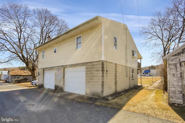 view of side of property featuring a garage, driveway, and a chimney