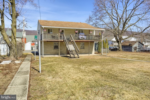 rear view of property featuring stairway, a patio, a yard, and a wooden deck