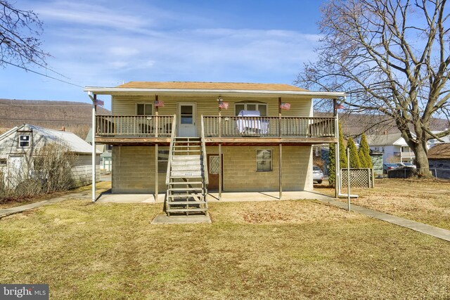 back of property with a patio area, stairway, a lawn, and a deck