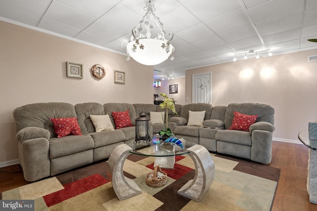 living area with visible vents, ornamental molding, baseboards, and wood finished floors