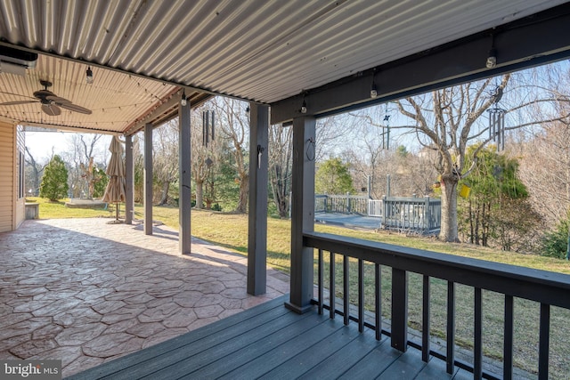 wooden terrace with a patio area, a lawn, and ceiling fan