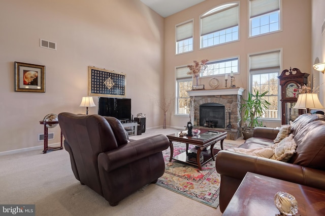 living area with a wealth of natural light, visible vents, baseboards, and carpet flooring