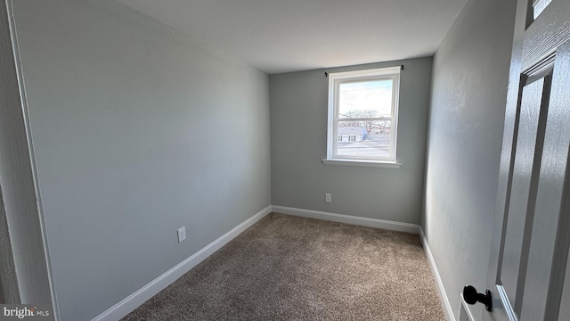 unfurnished room with baseboards and carpet