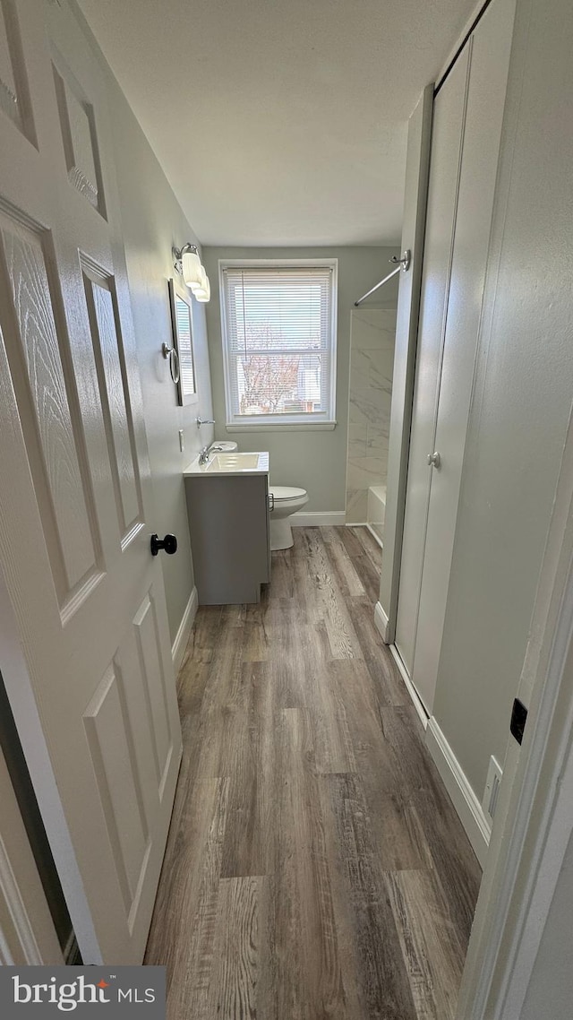 bathroom featuring vanity, shower / tub combination, toilet, and wood finished floors