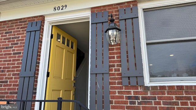 entrance to property featuring brick siding