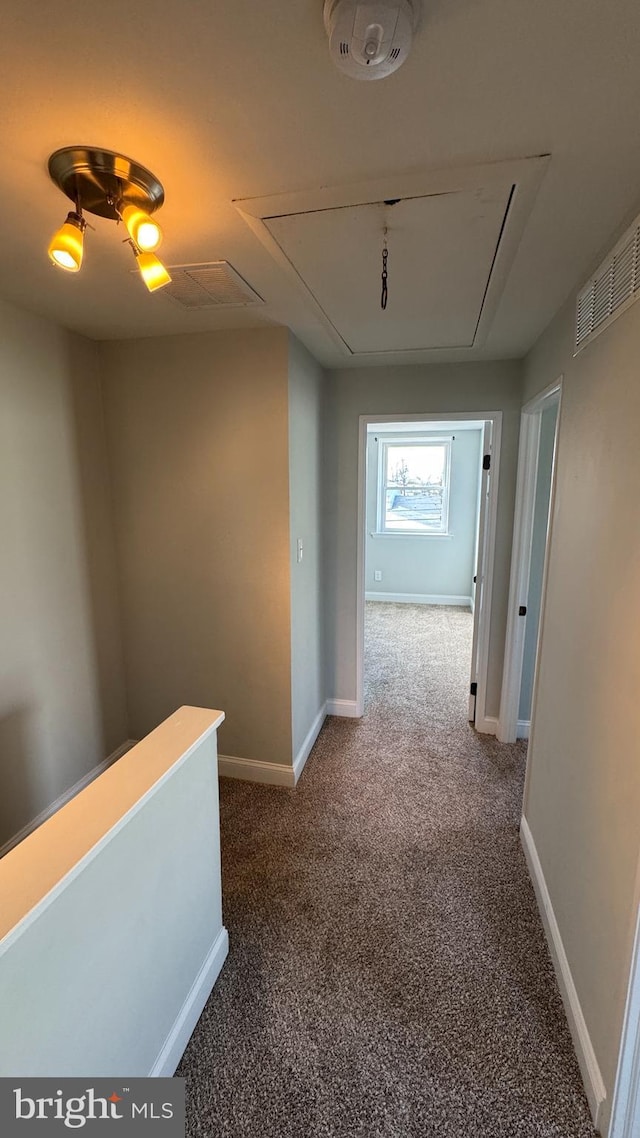 corridor featuring attic access, carpet flooring, baseboards, and visible vents