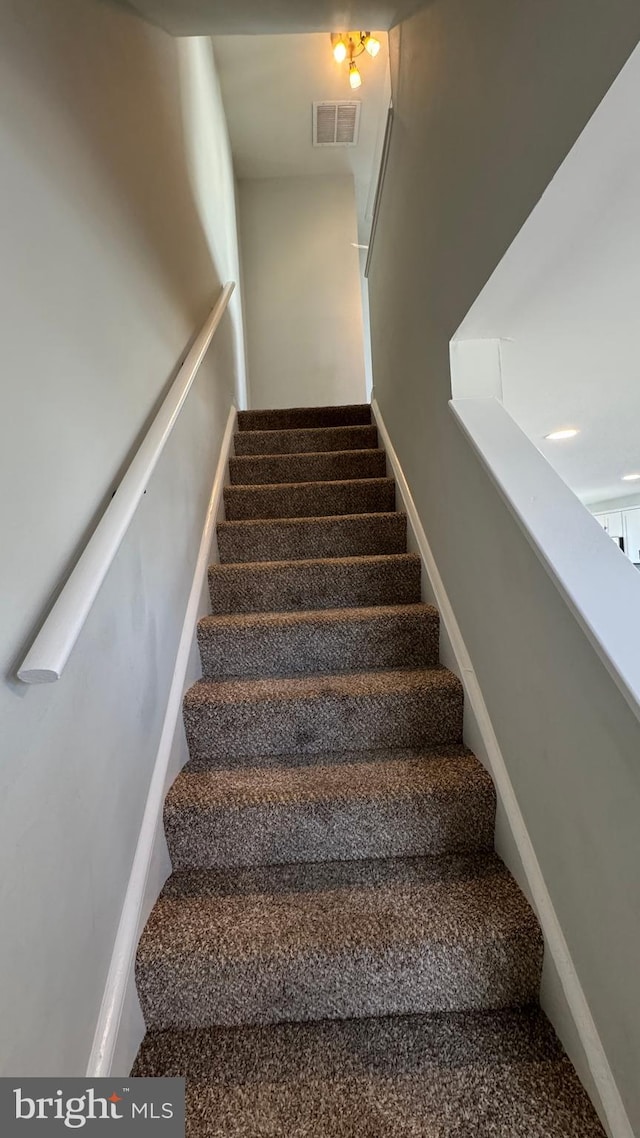 staircase with visible vents and baseboards