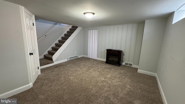 finished below grade area with baseboards, visible vents, stairs, a baseboard heating unit, and carpet flooring